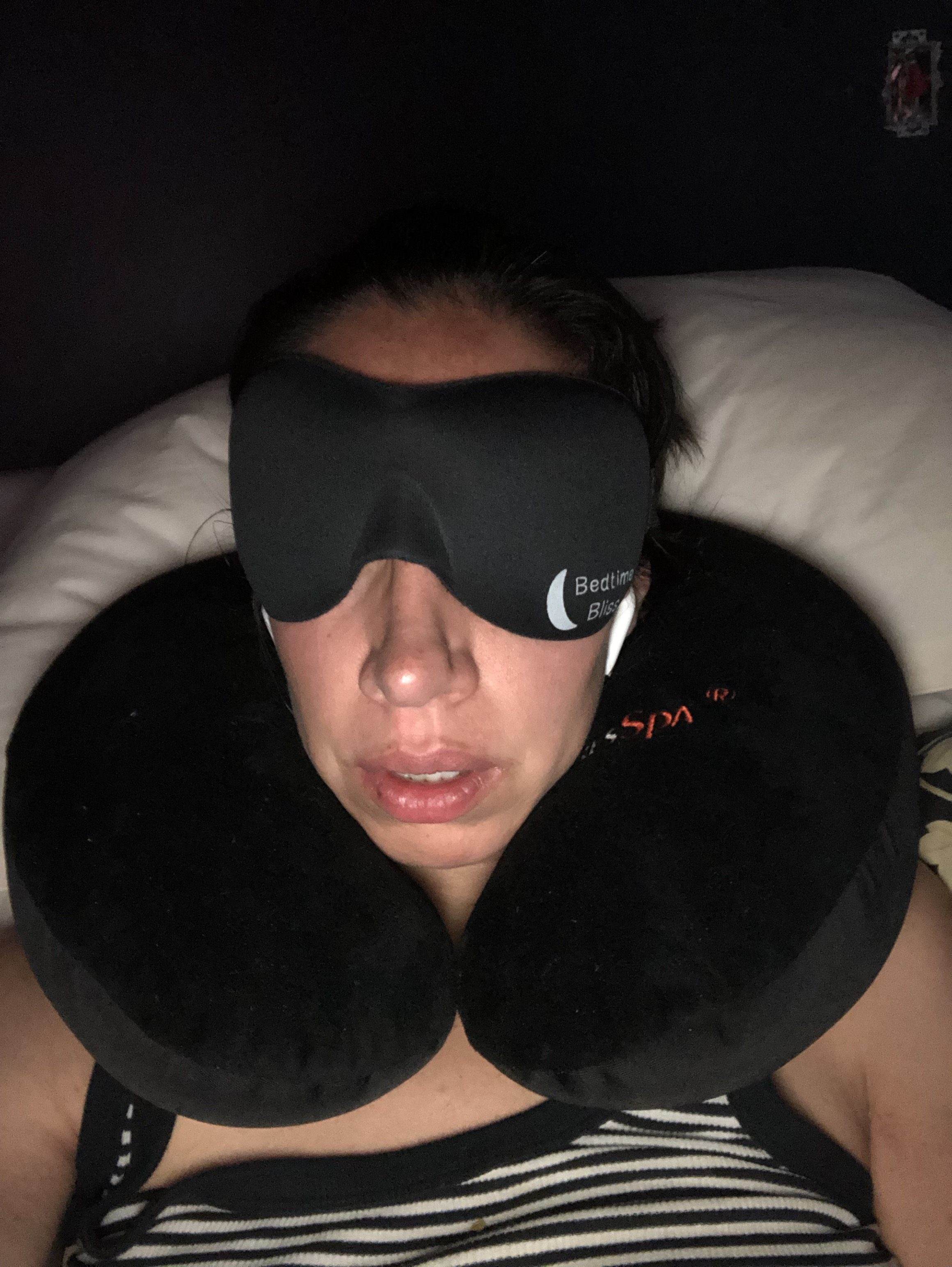 woman with eye mask and airplane pillow
