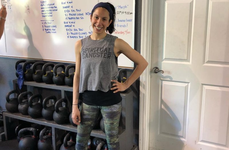 woman standing in front of weights