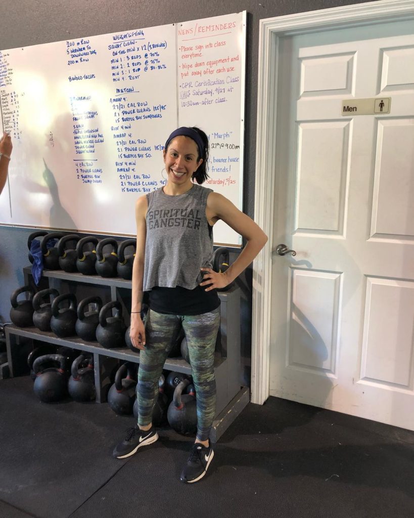 woman standing in front of weights