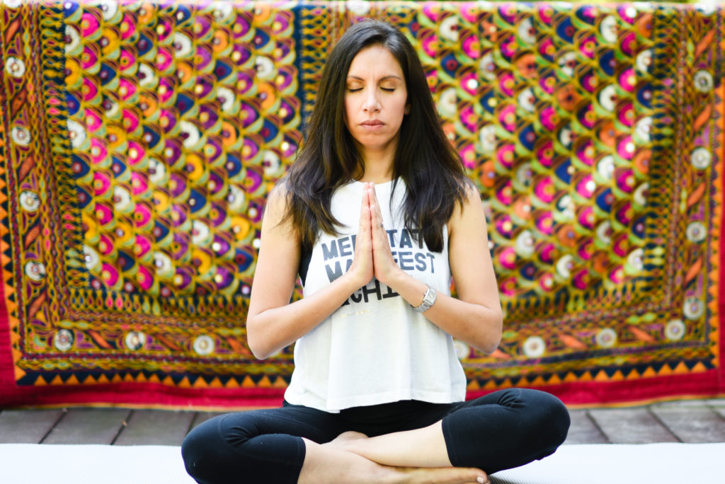 woman in lotus post with hands in prayer